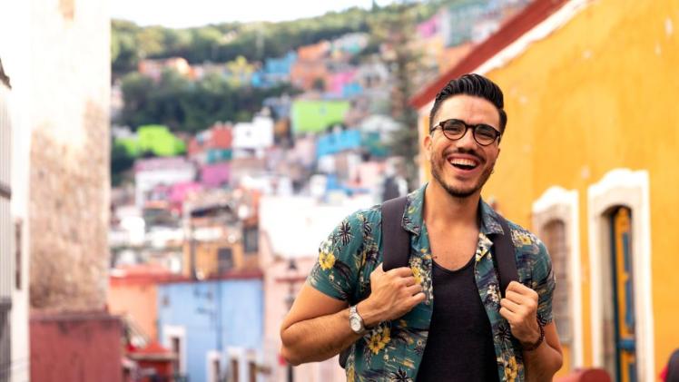 male student standing smiling with backpack